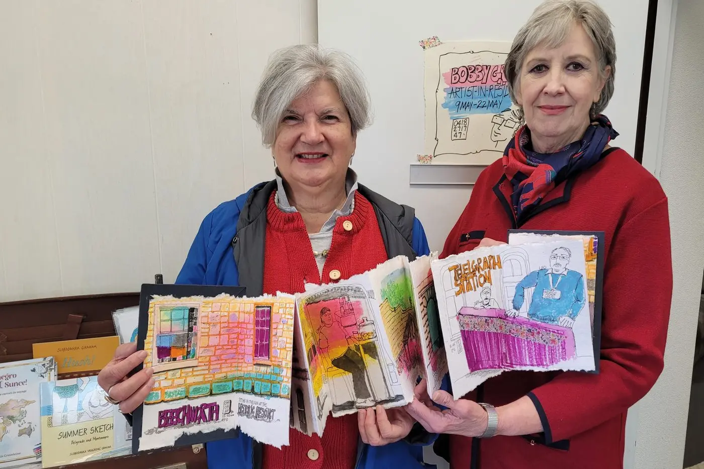 CREATIVE: Artist in residence Bobby Graham (left) with her sketchbook with Mayday Hills Art Society co-founder Christine-Cansfield Smith. PHOTO: Coral Cooksley