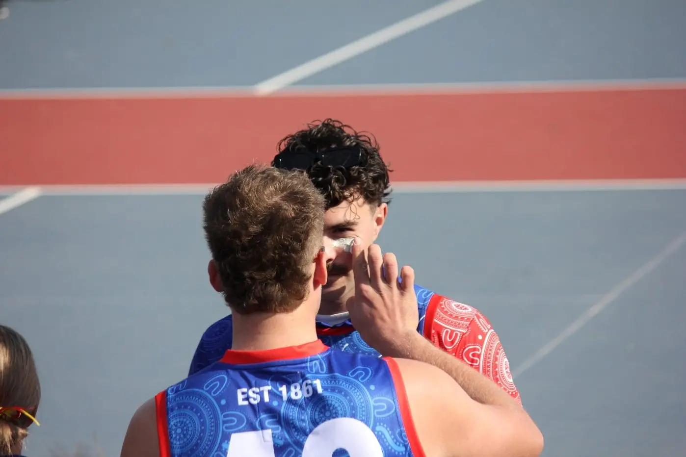 TEAM WORK: A teammate applying ochre to Tristan Lenaz during the pre-match celebrations.