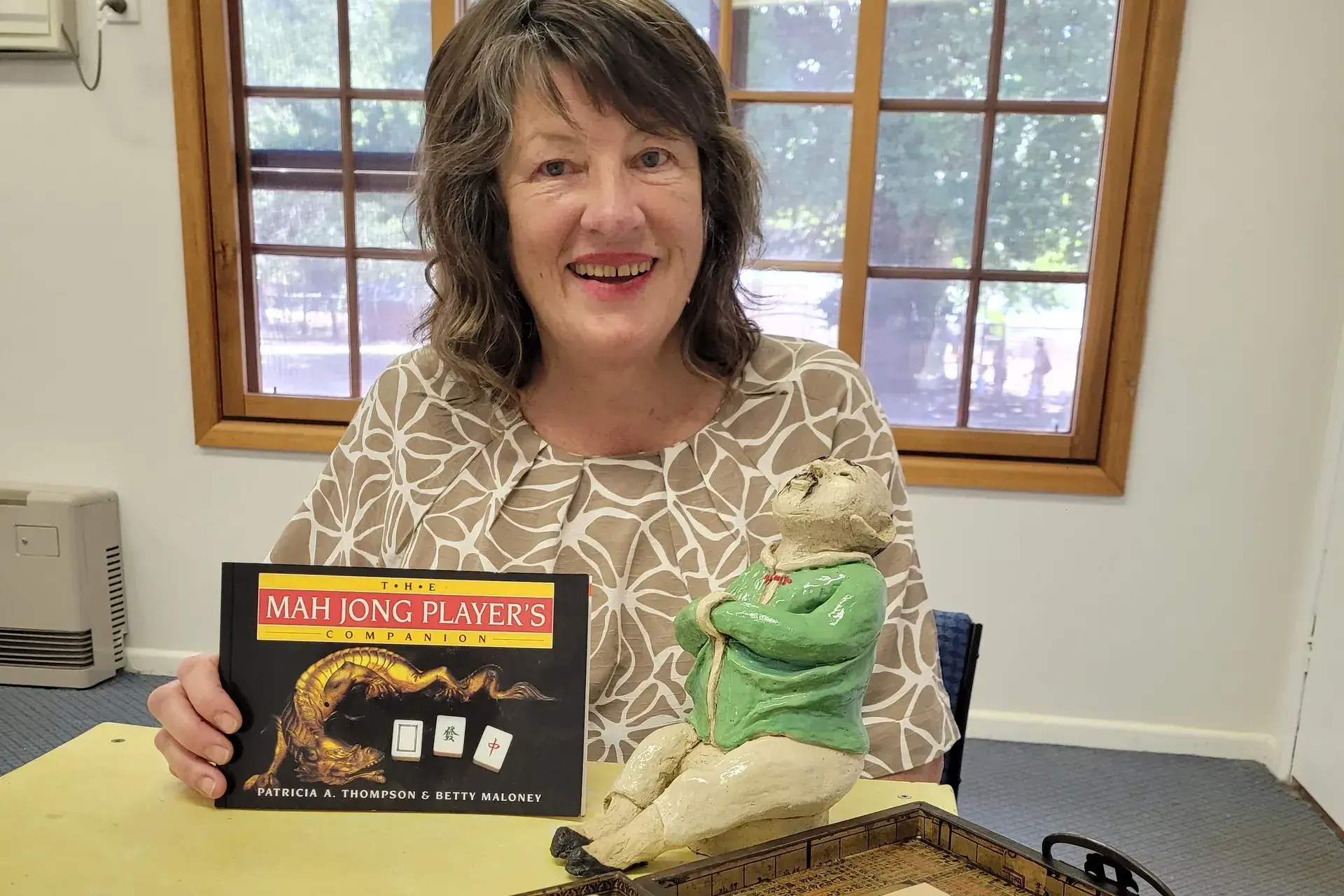 <p>FUN: Stanley artist and the village\\u2019s hall and athenaeum committee of management secretary Martine Valentine is excited to bring Mahjong to the community. Photographed with her hand-crafted Chinese figurine as a mascot. PHOTO: Coral Cooksley</p>\\n