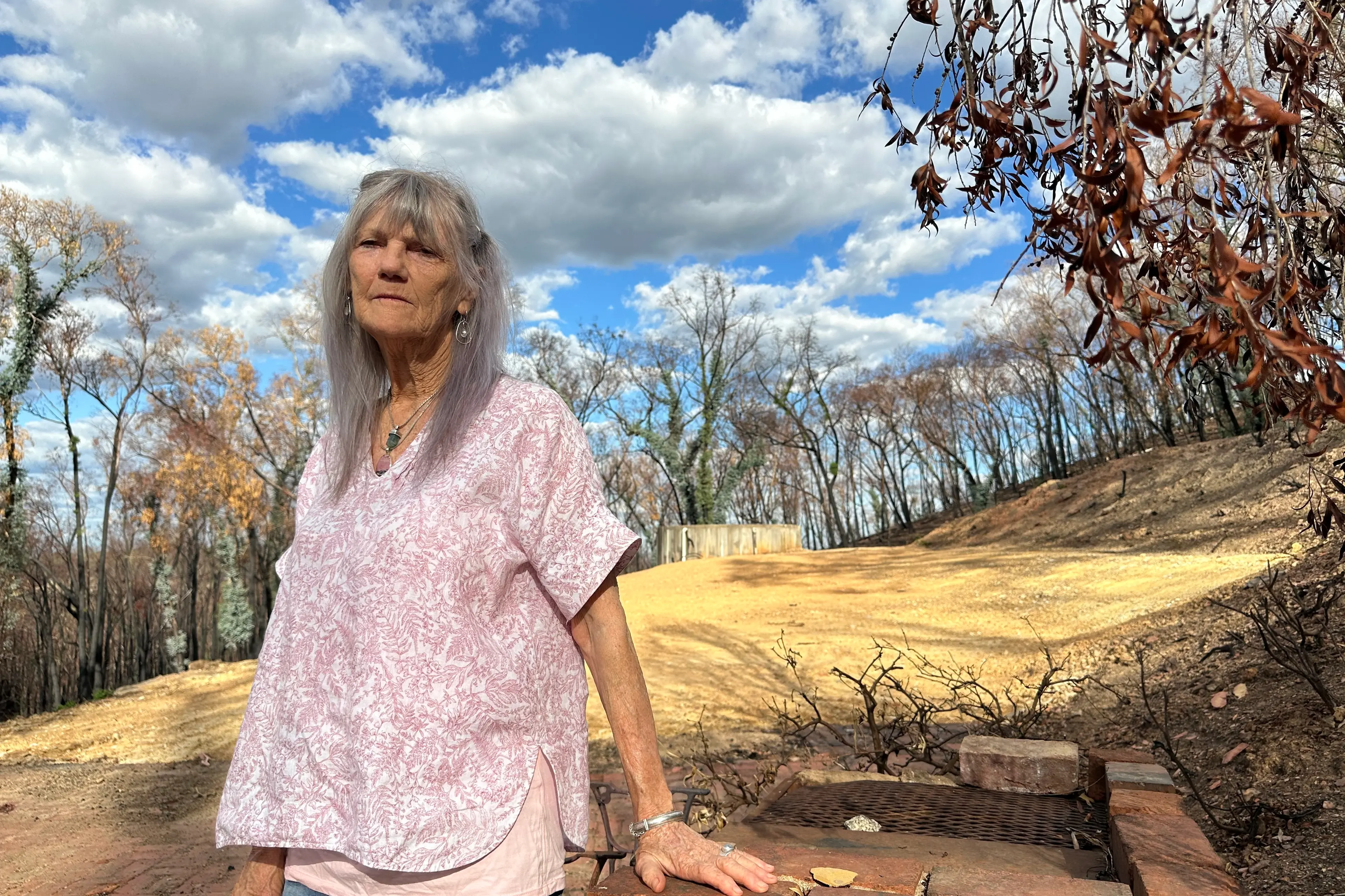 <p>AN EMPTY FEELING: Leshya Perkins, standing beside the barbeque of her former home, is making a final plea for government support she has been denied following the destruction of her home. PHOTO: Bailey Zimmermann</p>\\n