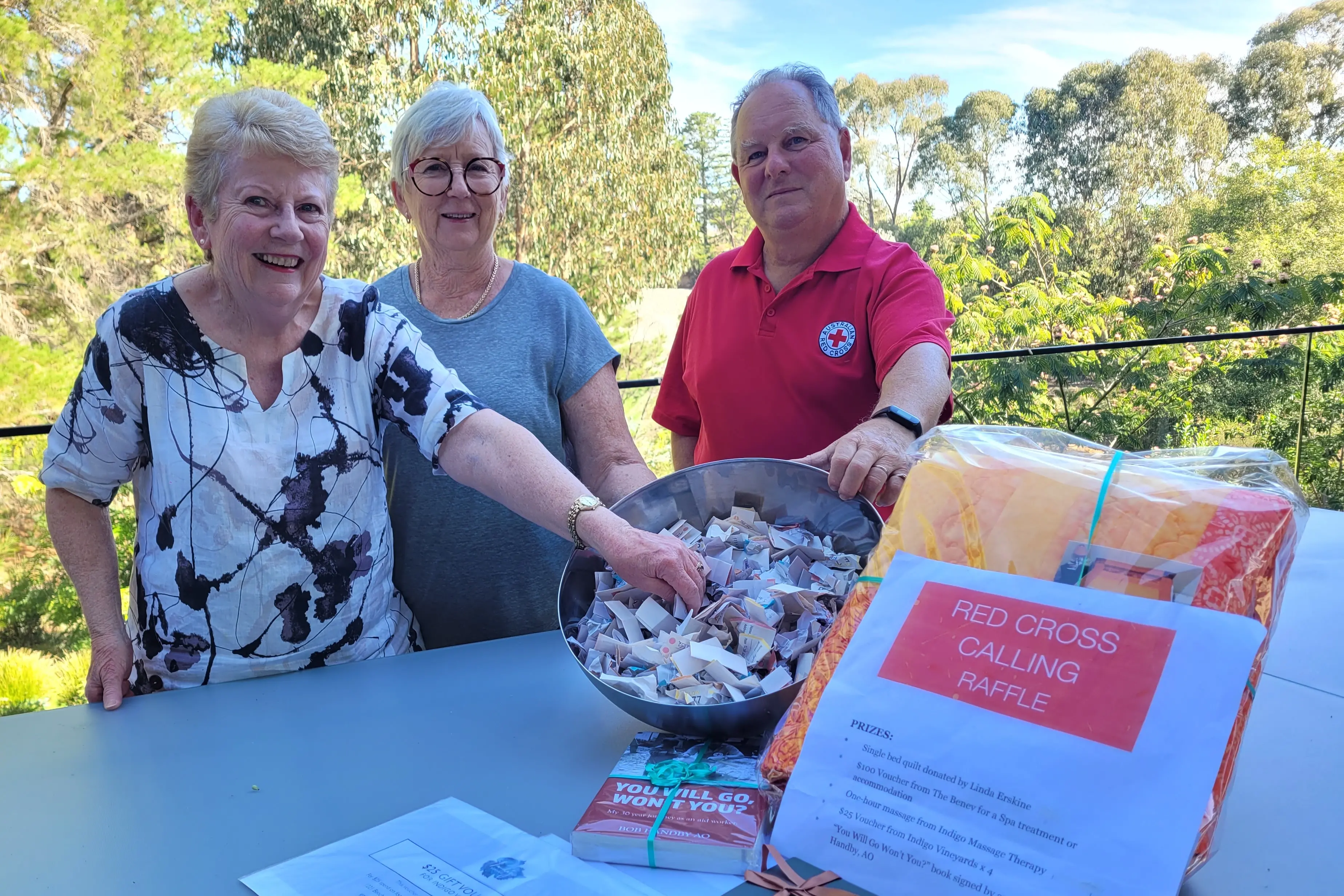 <p>RED CROSS CALLING: Local Red Cross Branch president Julia Smith (left), assistant treasurer Wendy Kelly with member Simon Kelly at the raffle draw. PHOTO: Coral Cooksley</p>\\n